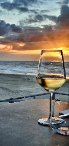 Sunset wine at Strandpaviljoen Paal 17 Aan Zee on Texel, Netherlands.